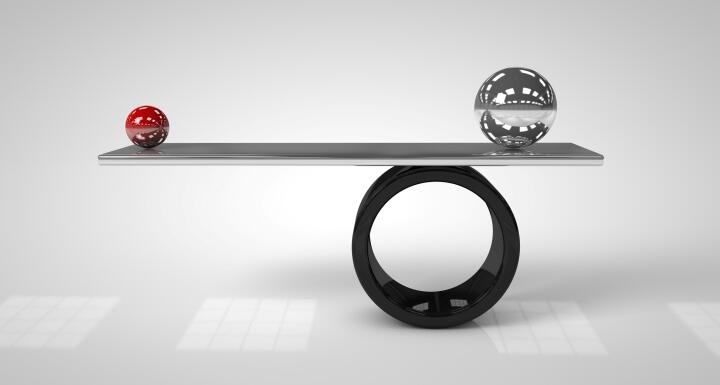 One red ball and one silver ball balancing on a board