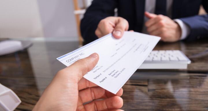 Businessman handing over check
