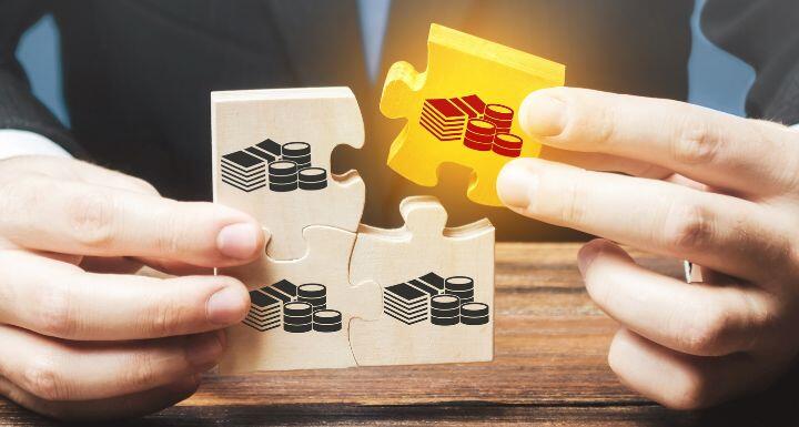 Businessman holds the wooden puzzle with a picture of money