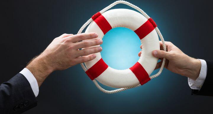 Businessmen Passing Lifebuoy Over Blue Background