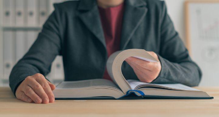 Businesswoman reading book at office desk