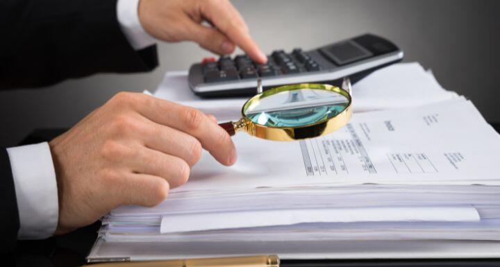close up of businessperson's hands with magnifying glass