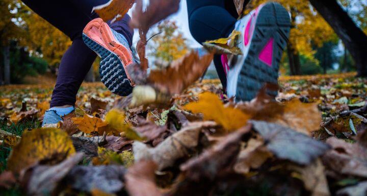 close up of two sole of shoes running through park