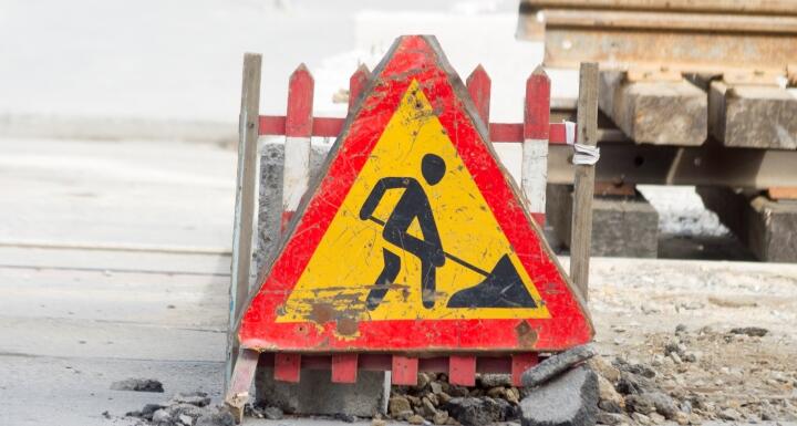A  large construction caution sign for drivers prominently displayed on a construction site