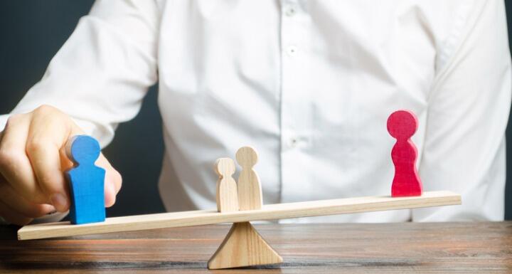 Wooden Parents on the opposite ends of a seesaw with kids in middle