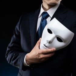 A businessman holding a mask