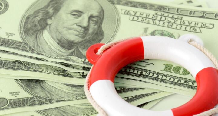 Red and white life buoy on top of paper money