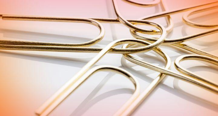FIVE GOLD PAPER CLIPS CONNECTED IN A CIRCLE