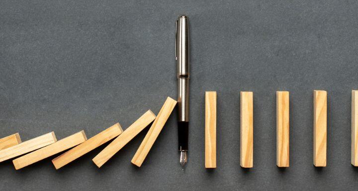Pen stopping dominoes from falling