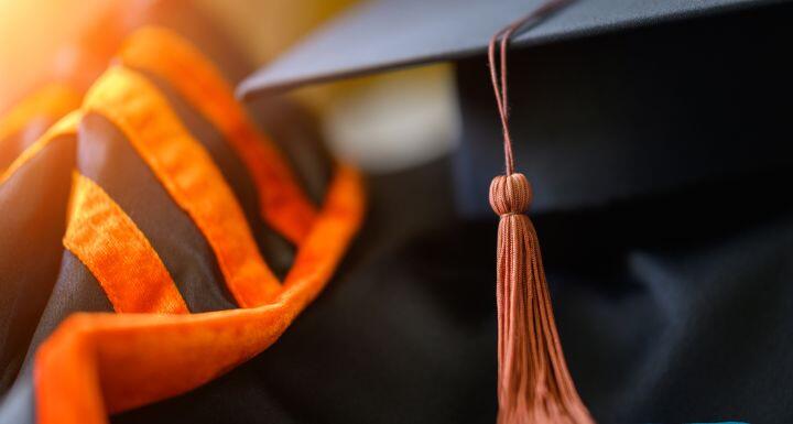 PhD graduate in black graduatioN gown University degree