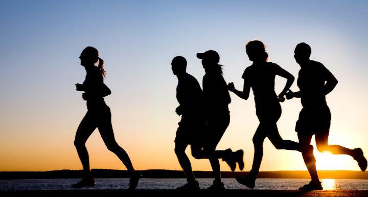silhouette of runners at the beach