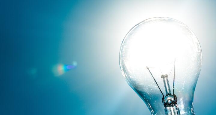 Standard Incandescent Light Bulb on Blue Background